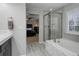Well-lit bathroom featuring a soaking tub and glass-enclosed shower at 15372 E 117Th Ave, Commerce City, CO 80022
