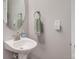 A well-lit powder room features a pedestal sink, and modern fixtures at 15372 E 117Th Ave, Commerce City, CO 80022