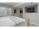 This bedroom has gray carpets, white walls, and a modern-looking TV at 15372 E 117Th Ave, Commerce City, CO 80022