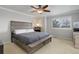 This cozy bedroom features a ceiling fan and a large window for natural light at 15372 E 117Th Ave, Commerce City, CO 80022