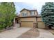 Charming two-story home featuring a three-car garage, a welcoming front porch, and mature trees at 15372 E 117Th Ave, Commerce City, CO 80022