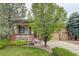 Beautiful home with a well-manicured lawn, mature trees, and a charming front porch at 15372 E 117Th Ave, Commerce City, CO 80022