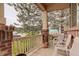 Inviting front porch featuring brick accents, white railings, and seating area at 15372 E 117Th Ave, Commerce City, CO 80022