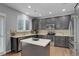 Well-lit kitchen featuring stainless steel appliances, ample dark cabinets, and a functional center island at 15372 E 117Th Ave, Commerce City, CO 80022