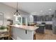 Modern kitchen with sleek, dark cabinetry, a breakfast bar, and wood flooring for a warm and inviting atmosphere at 15372 E 117Th Ave, Commerce City, CO 80022