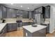 The kitchen features stainless appliances, sleek dark cabinetry, light countertops, and a functional island at 15372 E 117Th Ave, Commerce City, CO 80022