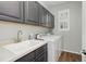 A convenient laundry room features modern washer/dryer, tile countertops, and storage at 15372 E 117Th Ave, Commerce City, CO 80022