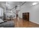 Open-concept living area with hardwood floors, staircase, and modern decor at 15372 E 117Th Ave, Commerce City, CO 80022