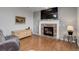 Cozy living room featuring a brick fireplace, hardwood floors, and comfortable seating at 15372 E 117Th Ave, Commerce City, CO 80022