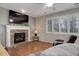 Bright living room featuring fireplace, hardwood floors, and a cozy armchair at 15372 E 117Th Ave, Commerce City, CO 80022