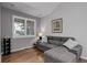 Living room with gray sofa, hardwood floors, and window shutters at 15372 E 117Th Ave, Commerce City, CO 80022