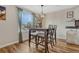 Cozy dining area featuring a wooden table with four chairs, wood-look floors, and natural light at 9401 Otis St, Broomfield, CO 80021