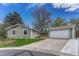 Charming single-story home with green siding, detached garage, manicured lawn and mature trees on a sunny day at 9401 Otis St, Broomfield, CO 80021