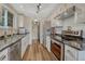 Well-lit kitchen featuring stainless steel appliances, white cabinets, wood-look floors and plenty of counter space at 9401 Otis St, Broomfield, CO 80021