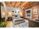Cozy bedroom with exposed brick, wooden ceiling, and modern lighting at 1792 Wynkoop St # 505, Denver, CO 80202