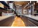 Modern kitchen with stainless steel appliances, exposed brick walls, wood floors, custom cabinetry, and an island with a breakfast bar at 1792 Wynkoop St # 505, Denver, CO 80202
