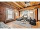 Well-lit living room featuring exposed brick, wood floors, and comfortable sectional sofa at 1792 Wynkoop St # 505, Denver, CO 80202