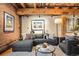 Comfortable living room featuring a large sectional sofa, exposed brick wall, and wooden beams at 1792 Wynkoop St # 505, Denver, CO 80202