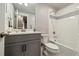 Modern bathroom with a gray vanity, white countertops, and a tiled shower-tub combination at 6334 N Dayton Way, Denver, CO 80238