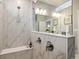 Sleek marble shower with glass panel and bench, complimented with modern fixtures and finishes at 6334 N Dayton Way, Denver, CO 80238