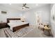 Bedroom with dark wood bed frame, ceiling fan, and adjacent bath at 6334 N Dayton Way, Denver, CO 80238