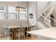 Elegant dining room with modern lighting, a large window, and a view of the staircase at 6334 N Dayton Way, Denver, CO 80238