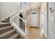 Bright foyer with stairs, light wood floors, statement chandelier, and a contemporary art piece at 6334 N Dayton Way, Denver, CO 80238
