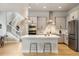 Bright kitchen featuring stainless steel appliances, a central island, and an adjacent staircase at 6334 N Dayton Way, Denver, CO 80238