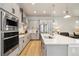 Modern kitchen with stainless steel appliances, gray cabinetry, and an open layout to the living space at 6334 N Dayton Way, Denver, CO 80238