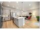 Open-concept kitchen with stainless steel appliances, a center island, and seamless flow to the living area at 6334 N Dayton Way, Denver, CO 80238