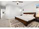 Bright bedroom offers neutral walls and a wood bed frame with a fuzzy area rug at 6334 N Dayton Way, Denver, CO 80238