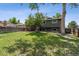 Large backyard with a covered patio, grass, and mature trees providing shade at 4502 S Gar Way, Littleton, CO 80123