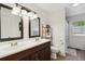 Bathroom featuring a double sink vanity, updated lighting, and a separate shower area at 4502 S Gar Way, Littleton, CO 80123