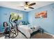Comfortable bedroom with blue walls, a ceiling fan, and a window that fills the room with light at 4502 S Gar Way, Littleton, CO 80123