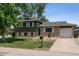 Charming home featuring a well-kept lawn, brick accents, attached garage, and inviting curb appeal at 4502 S Gar Way, Littleton, CO 80123
