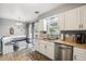 Bright kitchen with a stainless steel dishwasher and a breakfast nook with built-in bench seating at 4502 S Gar Way, Littleton, CO 80123