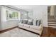 Bright living room with a comfortable sofa, patterned rug, and views of the front yard at 4502 S Gar Way, Littleton, CO 80123