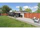Back yard with grass, covered patio, fenced area and decor seating under the pergola at 45 S Reed St, Lakewood, CO 80226