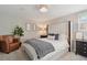 Cozy bedroom featuring a comfortable queen bed, plush chair, and warm lighting creating a relaxing and inviting space at 45 S Reed St, Lakewood, CO 80226