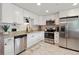 Modern kitchen boasts white cabinets, stainless steel appliances, and granite countertops at 45 S Reed St, Lakewood, CO 80226