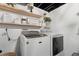 Laundry room featuring a new washer and dryer, updated lighting, and floating shelves at 45 S Reed St, Lakewood, CO 80226