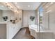 Bright bathroom features white cabinetry, double sinks, soaking tub and shower at 1221 Havenwood Way, Castle Pines, CO 80108
