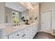 Bright bathroom features white cabinetry, double sinks and a large mirror at 1221 Havenwood Way, Castle Pines, CO 80108