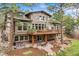Back of house with walkout basement, deck, brick accents, and patio with seating at 1221 Havenwood Way, Castle Pines, CO 80108
