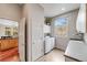 Well-lit laundry room with modern appliances, a utility sink, and plenty of storage space at 1221 Havenwood Way, Castle Pines, CO 80108