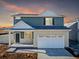 Charming two-story home featuring blue siding and a welcoming front porch at sunset at 3869 N Shawee St, Aurora, CO 80019