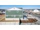 A back view of the house shows green vinyl siding and a walkout basement at 3869 N Shawee St, Aurora, CO 80019