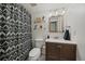 Modern bathroom with patterned shower curtain, vanity with dark wood cabinets and shelf storage at 8335 Fairmount Dr # 2-105, Denver, CO 80247