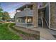 Two-story condo featuring stone accents, a private balcony, and well-maintained landscaping at 8335 Fairmount Dr # 2-105, Denver, CO 80247
