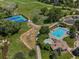 Aerial view of a community pool with a clubhouse, tennis courts, and a golf course at 7131 S Wenatchee Way # C, Aurora, CO 80016